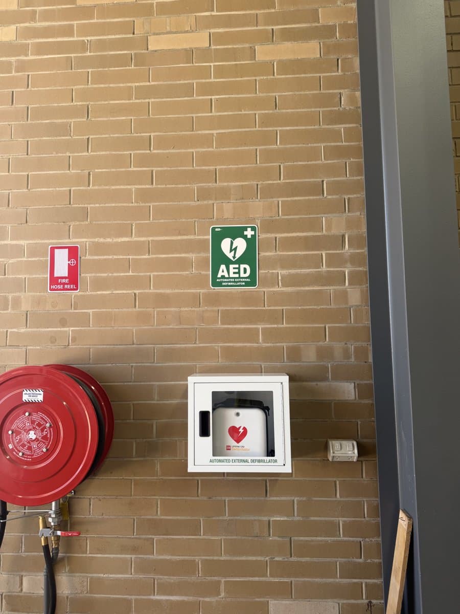 AED defibrillator cabinet installation with compliance signage by ADs Maintenance Adelaide